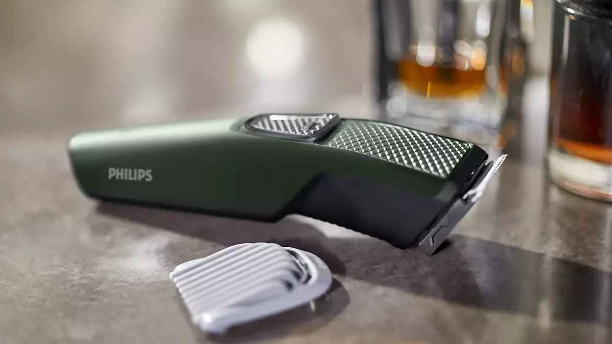 Philips BT1230/15 trimmer shown resting beside its 5 mm comb attachment